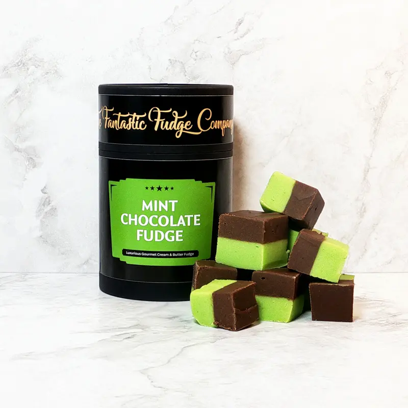 A round box of mint chocolate fudge with several square pieces of delicious mint chocolate fudge placed beside it.