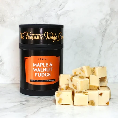A round box of maple & nut fudge with several square pieces of delicious fudge placed beside it.